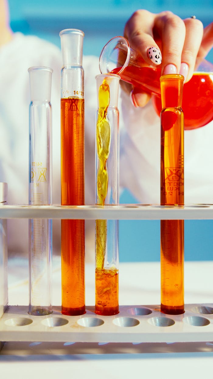 Close-Up Photo Of A Person Pouring Mixture On A Tube